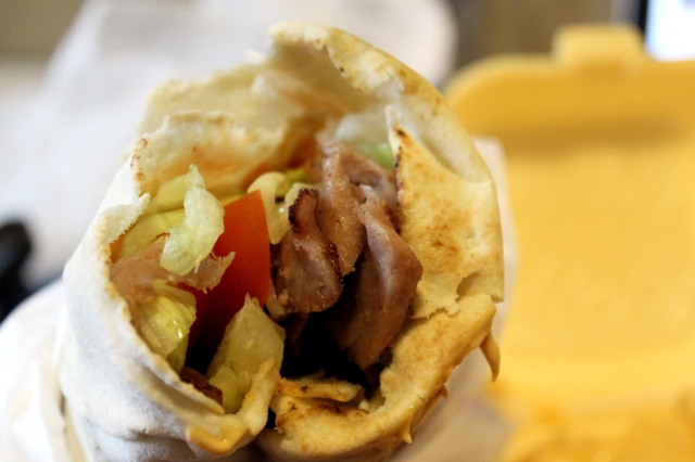 Grilled lamb shawarma with salad (lettuce, tomatoes, and onions), garlic mayo, hot sauce, all wrapped in pita. Served with a side of thick chips (fries).